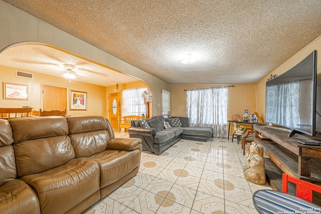 3211 Hatton, San Antonio, TX 78237 - living room featuring a textured ceiling, light tile patterned floors, ceiling fan, and arched walkways