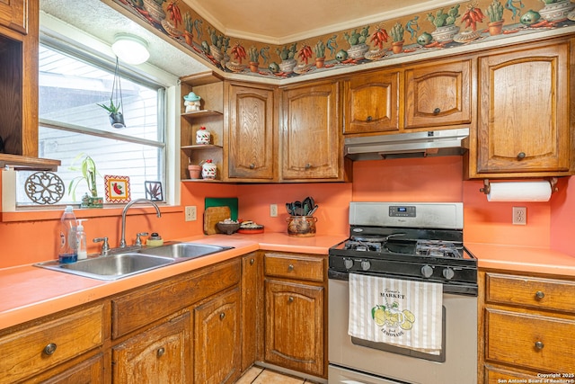 3211 Hatton, San Antonio, TX 78237 - kitchen with stainless steel range with gas cooktop, under cabinet range hood, a sink, brown cabinets, and crown molding