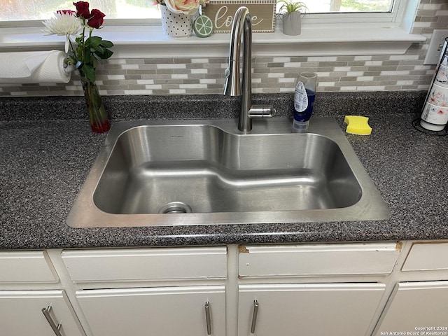 9858 Menard Cir, San Antonio, TX 78245 - kitchen view of backsplash, dark countertops, and white cabinetry