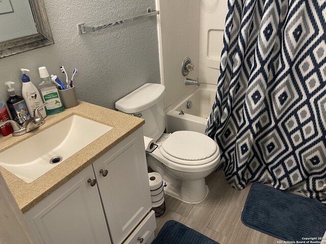 9858 Menard Cir, San Antonio, TX 78245 - bathroom with a textured wall, vanity, shower / tub combo with curtain, and wood finished floors