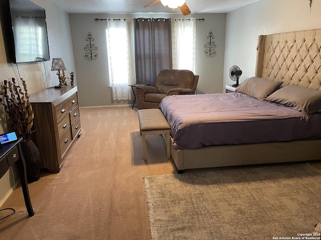 9858 Menard Cir, San Antonio, TX 78245 - bedroom with light carpet, a textured ceiling, and a ceiling fan