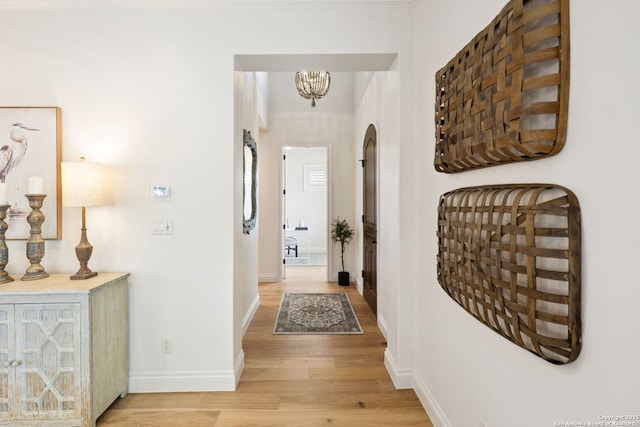 172 Katherine Ct Unit 1, San Antonio, TX 78209 - hall with light wood-type flooring, a chandelier, baseboards, and arched walkways
