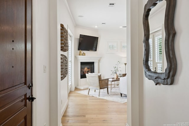 172 Katherine Ct Unit 1, San Antonio, TX 78209 - entryway featuring light wood-type flooring, ornamental molding, a glass covered fireplace, and baseboards