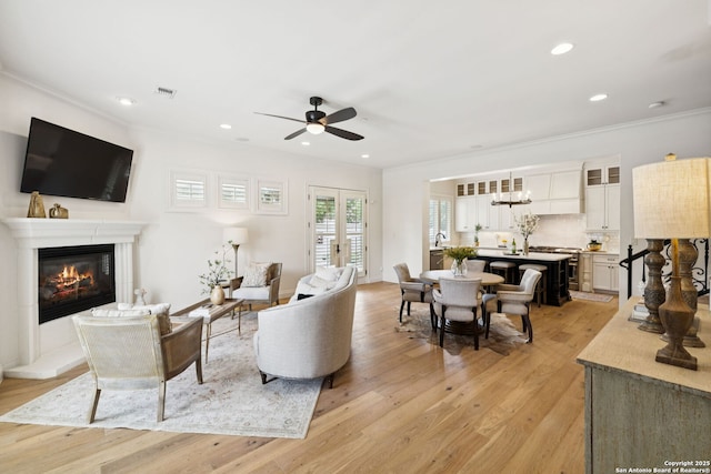 172 Katherine Ct Unit 1, San Antonio, TX 78209 - living room with crown molding, ceiling fan, light wood-type flooring, a glass covered fireplace, and recessed lighting