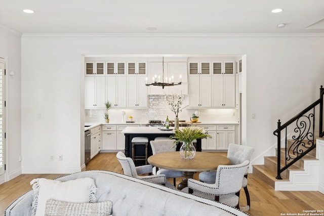 172 Katherine Ct Unit 1, San Antonio, TX 78209 - kitchen featuring backsplash, light countertops, ornamental molding, light wood-type flooring, and white cabinetry
