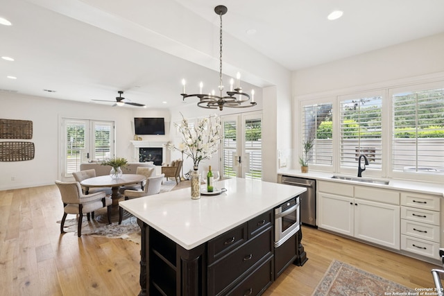 172 Katherine Ct Unit 1, San Antonio, TX 78209 - kitchen with stainless steel dishwasher, a sink, light countertops, a fireplace, and recessed lighting