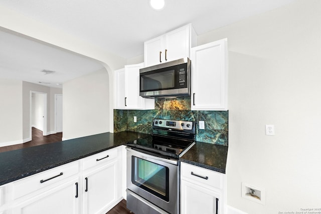 15831 Colton Wl, San Antonio, TX 78247 - kitchen featuring appliances with stainless steel finishes, decorative backsplash, a peninsula, white cabinets, and arched walkways