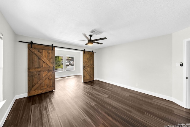 15831 Colton Wl, San Antonio, TX 78247 - unfurnished room featuring a barn door, a ceiling fan, dark wood finished floors, baseboards, and a textured ceiling