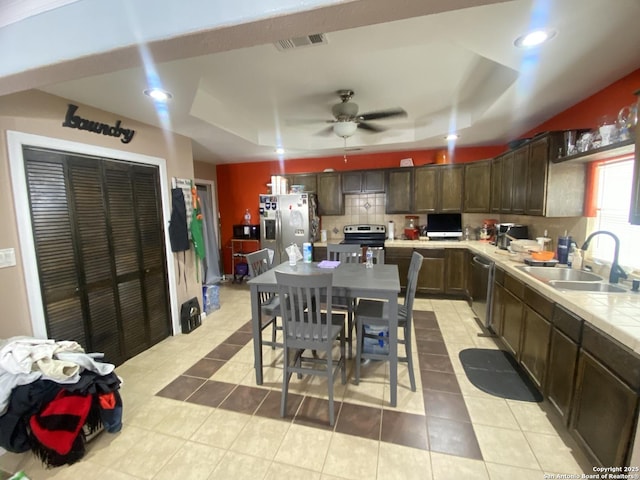 1202 Pine, Orange, TX 77630 - kitchen featuring stainless steel appliances, a sink, a tray ceiling, decorative backsplash, and recessed lighting