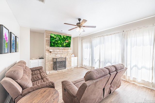 132 Las Palomas Ln, Vernia, TX 78121 - living area with light wood finished floors, a stone fireplace, a ceiling fan, and baseboards