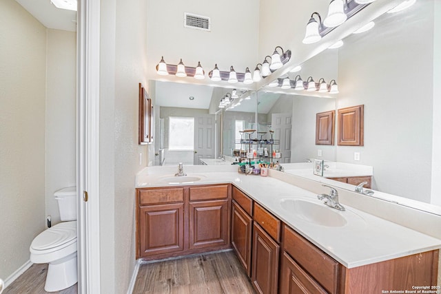 132 Las Palomas Ln, Vernia, TX 78121 - full bathroom with wood finished floors, double vanity, toilet, baseboards, and a towering ceiling