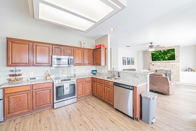 132 Las Palomas Ln, Vernia, TX 78121 - kitchen featuring stainless steel appliances, a sink, brown cabinetry, light wood-type flooring, and recessed lighting