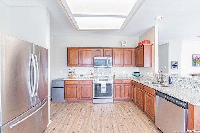 132 Las Palomas Ln, Vernia, TX 78121 - kitchen with appliances with stainless steel finishes, a sink, light wood-type flooring, brown cabinetry, and recessed lighting