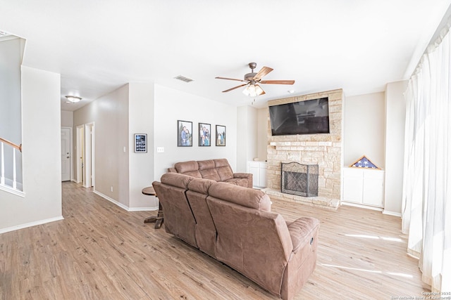 132 Las Palomas Ln, Vernia, TX 78121 - living area featuring light wood-style floors, a ceiling fan, a fireplace, baseboards, and stairs