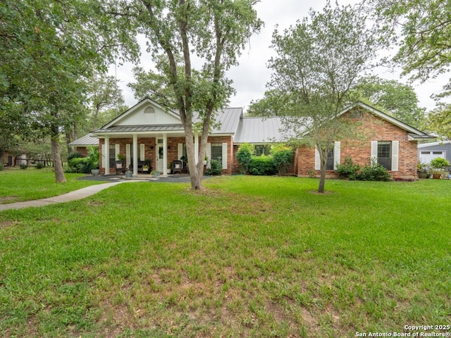 120 Spanish Oak Trl, Floresville, TX 78114 - neoclassical home with covered porch, a front yard, a standing seam roof, brick siding, and metal roof