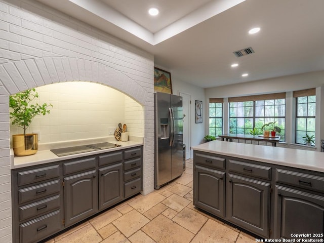 120 Spanish Oak Trl, Floresville, TX 78114 - kitchen featuring stainless steel fridge with ice dispenser, light countertops, electric stovetop, stone tile flooring, and recessed lighting