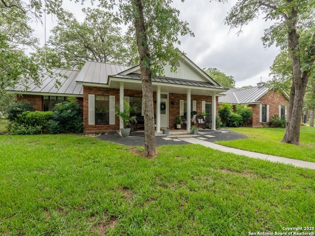 120 Spanish Oak Trl, Floresville, TX 78114 - view of front facade with a standing seam roof, a porch, a front yard, and metal roof