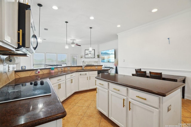 7027 Laura Hts, Schertz, TX 78154 - kitchen with dark countertops, a sink, black electric cooktop, crown molding, and light tile patterned floors