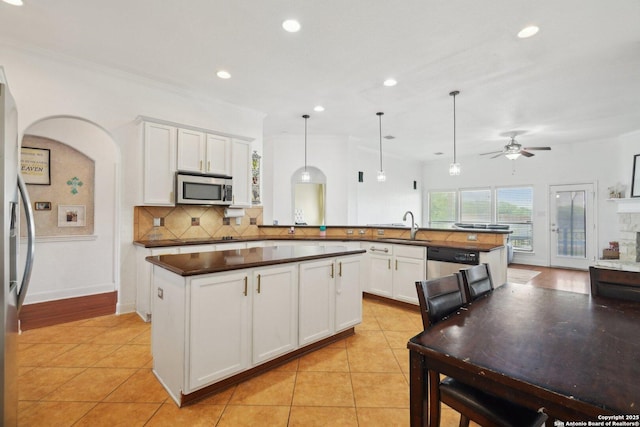7027 Laura Hts, Schertz, TX 78154 - kitchen featuring stainless steel appliances, a peninsula, dark countertops, tasteful backsplash, and a ceiling fan