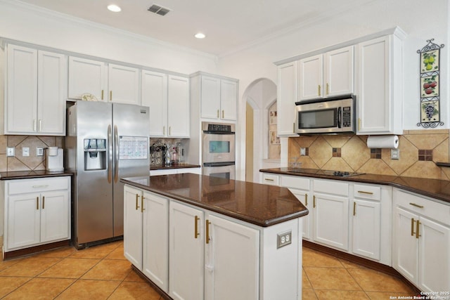 7027 Laura Hts, Schertz, TX 78154 - kitchen with stainless steel appliances, arched walkways, a kitchen island, crown molding, and decorative backsplash