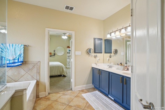 7027 Laura Hts, Schertz, TX 78154 - ensuite bathroom with double vanity, tile patterned flooring, a garden tub, a ceiling fan, and baseboards