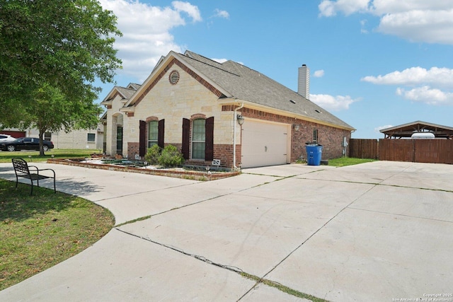 7027 Laura Hts, Schertz, TX 78154 - view of front of house featuring driveway, an attached garage, a chimney, brick siding, and stone siding