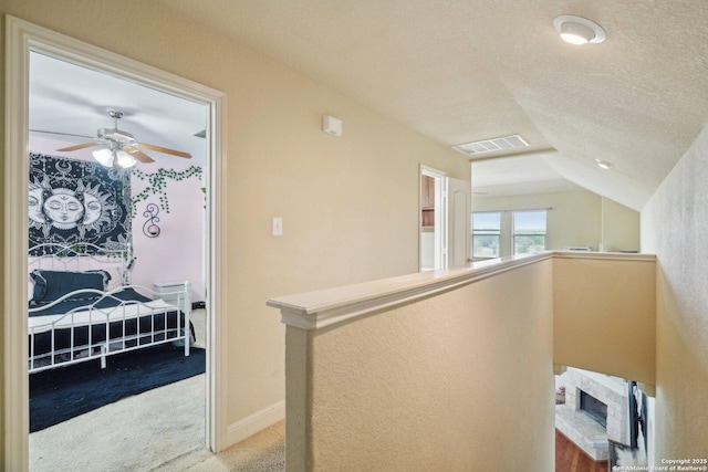 7027 Laura Hts, Schertz, TX 78154 - hallway with carpet, lofted ceiling, an upstairs landing, and a textured ceiling