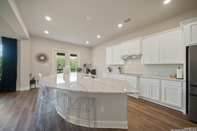 418 Sundance Way, San Antonio, TX 78253 - kitchen featuring a sink, black electric cooktop, a center island with sink, freestanding refrigerator, and white cabinets