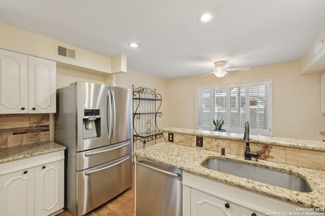 107-A Ruelle Unit 107-A, San Antonio, TX 78209 - kitchen with appliances with stainless steel finishes, a sink, a ceiling fan, white cabinets, and light stone countertops