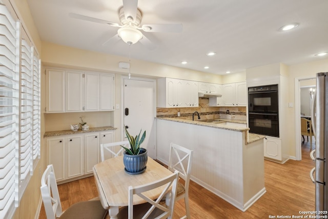 107-A Ruelle Unit 107-A, San Antonio, TX 78209 - kitchen featuring freestanding refrigerator, a ceiling fan, white cabinets, under cabinet range hood, and tasteful backsplash
