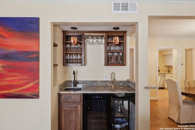 107-A Ruelle Unit 107-A, San Antonio, TX 78209 - indoor wet bar with stainless steel dishwasher, beverage cooler, wood finished floors, crown molding, and pendant lighting