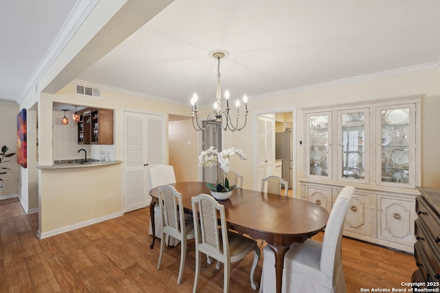 107-A Ruelle Unit 107-A, San Antonio, TX 78209 - dining area with a chandelier, crown molding, light wood finished floors, and baseboards