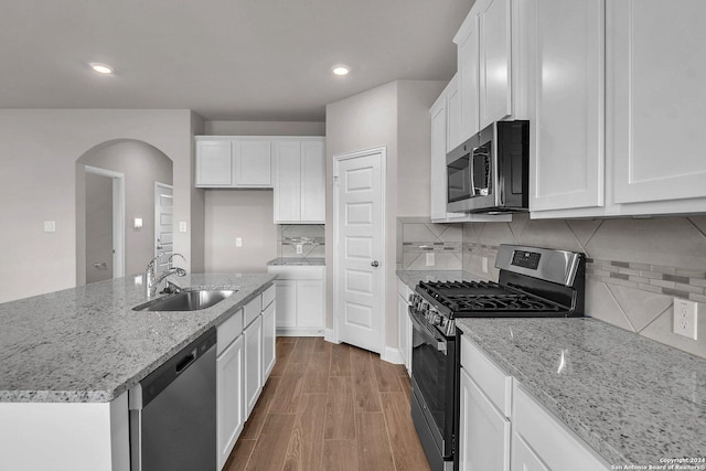 6538 Scooby Acres, San Antonio, TX 78108 - kitchen with stainless steel appliances, a sink, arched walkways, white cabinetry, and light stone counters