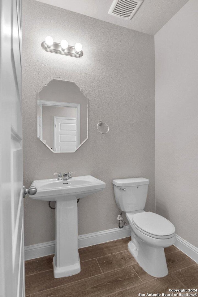 6538 Scooby Acres, San Antonio, TX 78108 - bathroom featuring toilet, baseboards, and wood tiled floors