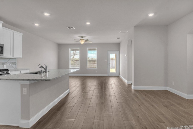 6538 Scooby Acres, San Antonio, TX 78108 - kitchen with a sink, dark wood-style flooring, baseboards, light stone countertops, and a ceiling fan
