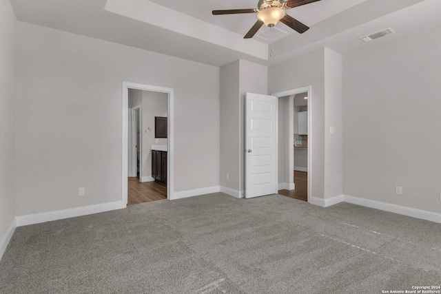 6538 Scooby Acres, San Antonio, TX 78108 - unfurnished bedroom with carpet floors, baseboards, connected bathroom, ceiling fan, and a tray ceiling