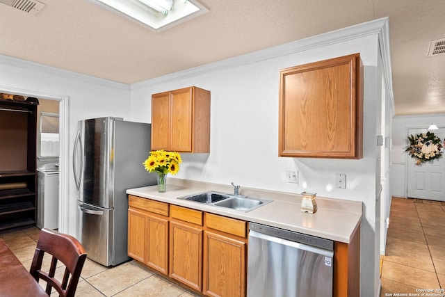 9014 Camino Rey, San Antonio, TX 78245 - kitchen featuring stainless steel appliances, a sink, light tile patterned flooring, crown molding, and light countertops