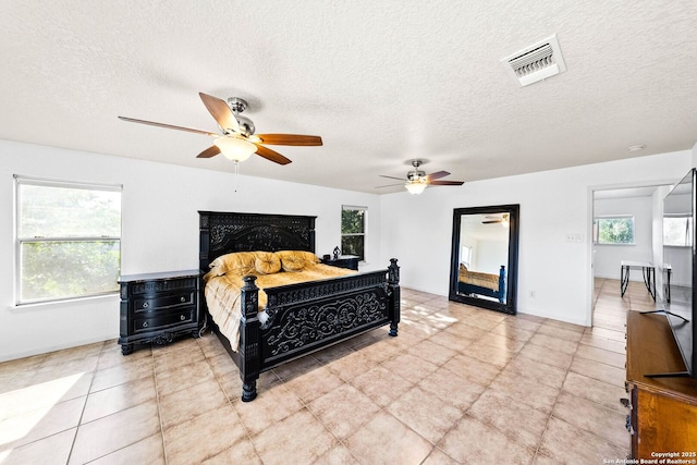 9014 Camino Rey, San Antonio, TX 78245 - bedroom with multiple windows, a textured ceiling, baseboards, light tile patterned floors, and a ceiling fan