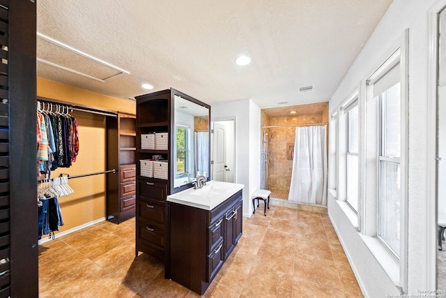 9014 Camino Rey, San Antonio, TX 78245 - full bathroom with tiled shower, vanity, a spacious closet, baseboards, and tile patterned floors