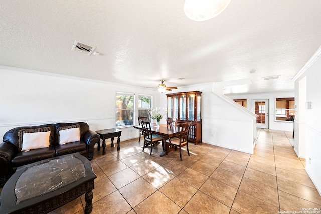 9014 Camino Rey, San Antonio, TX 78245 - dining room featuring light tile patterned flooring, a ceiling fan, a textured ceiling, and crown molding