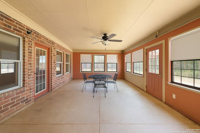 9014 Camino Rey, San Antonio, TX 78245 - sunroom with a ceiling fan, brick wall, finished concrete floors, outdoor dining area, and healthy amount of natural light
