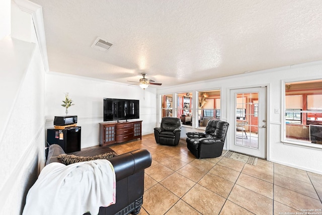 9014 Camino Rey, San Antonio, TX 78245 - living room featuring a ceiling fan, a textured ceiling, and light tile patterned floors