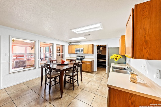 9014 Camino Rey, San Antonio, TX 78245 - dining space with light tile patterned floors, a skylight, and a textured ceiling