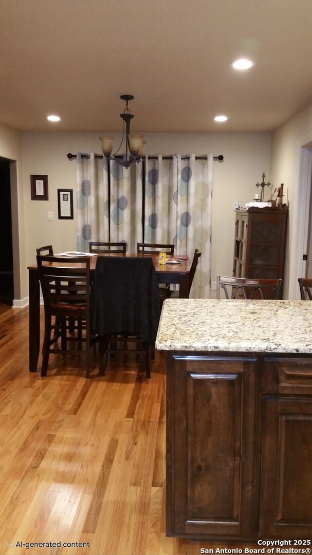 218 E Antonio, Uvalde, TX 78801 - kitchen with recessed lighting, light wood-type flooring, dark brown cabinetry, a chandelier, and light stone countertops