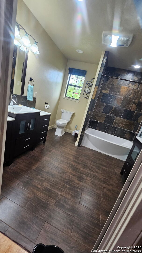 218 E Antonio, Uvalde, TX 78801 - bathroom with vanity, toilet, baseboards, and wood finished floors