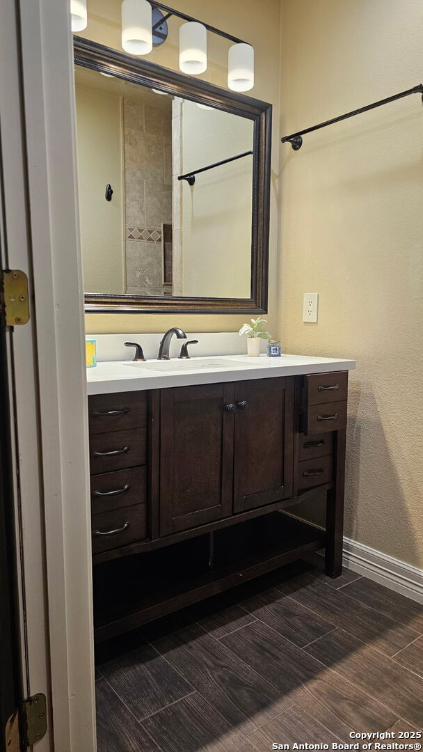 218 E Antonio, Uvalde, TX 78801 - bathroom with vanity, baseboards, and wood finished floors