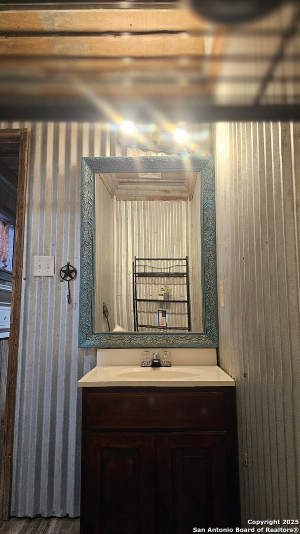 218 E Antonio, Uvalde, TX 78801 - bathroom featuring wallpapered walls and vanity
