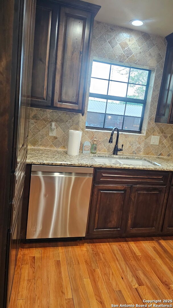 218 E Antonio, Uvalde, TX 78801 - kitchen with stainless steel dishwasher, decorative backsplash, a sink, light stone counters, and recessed lighting