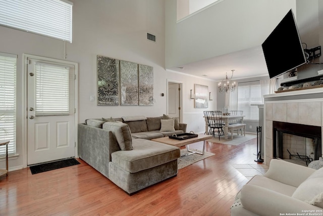 6039 Woodway Ct, San Antonio, TX 78249 - living room with light wood-style flooring, a chandelier, a high ceiling, and baseboards
