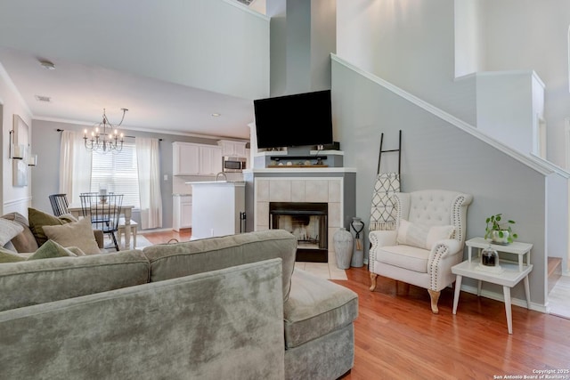 6039 Woodway Ct, San Antonio, TX 78249 - living room with a chandelier, light wood-type flooring, crown molding, and a fireplace